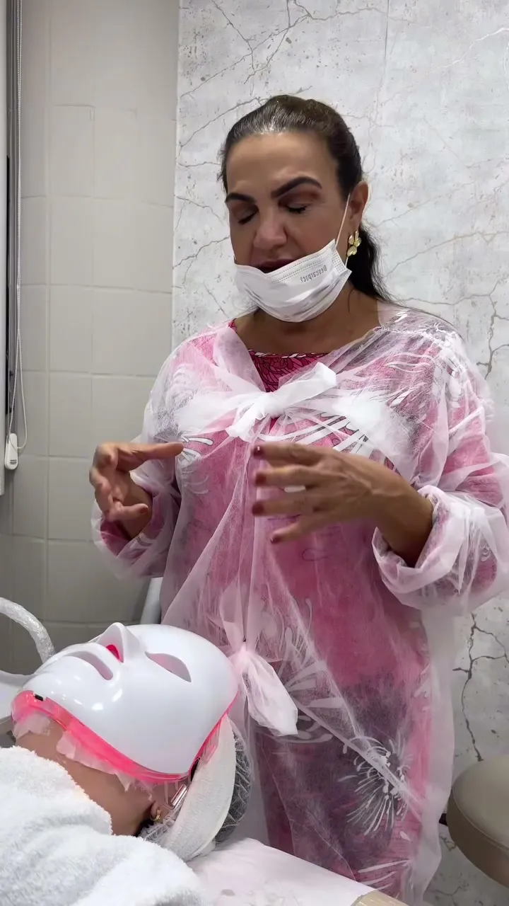 Ângela Meneghel atendendo uma cliente com a máscara de LED no espaço em Vitória